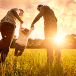 Couple swinging their child in a field