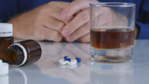 dark liquoe and white and green capsules on a table