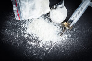 heroin and paraphernalia on black background