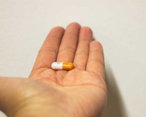 man-holding-addictive-adderall-pill