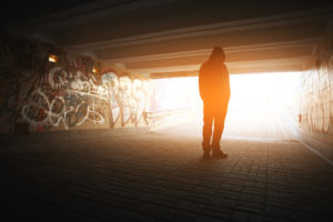 Man contemplating under a bridge