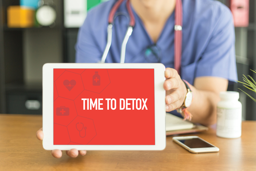 Nurse holding a laptop saying time to detox