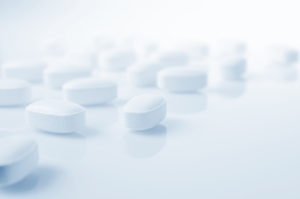 White pills on a light blue background