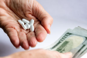 Pills and money being held
