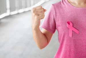 Woman in a pink shirt with a pink ribbon on it