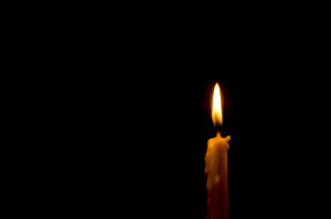 A single lit candle in the dark
