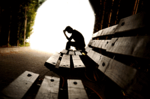 Person looking sad, sitting on a bench