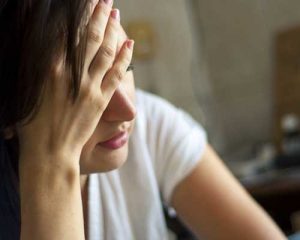 Stressed woman with her hand on her forehead