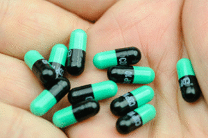 Green and black capsules in a palm