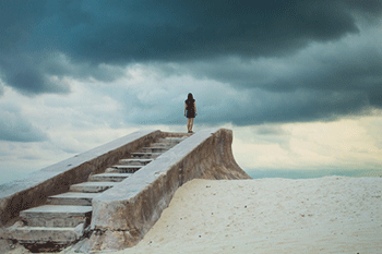 Woman at the top of a set of steps on the beach