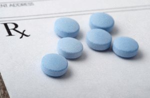 Blue pills on a blank prescription paper
