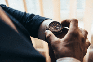 A man in a suit adjusting the time on his wristwatch