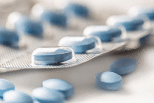 Light blue pills inside and outside of a blister pack