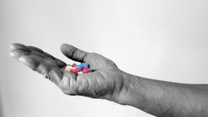 Colorful pills in a grey hand
