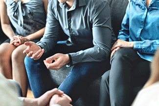 People in buttoned shirts sitting on a couch