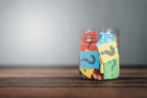 Sticky notes with question marks on them in a jar