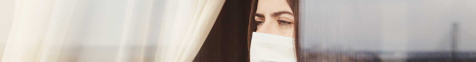 young-woman-stuck-in-quarantine-looks-out-window